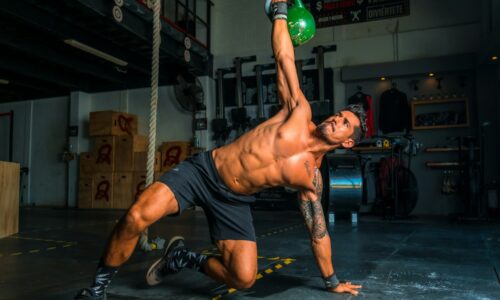 man in black shorts and black tank top doing push up