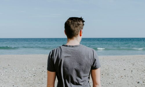 man standing on beach shore during daytime