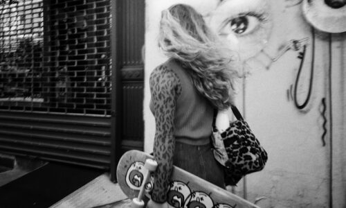 woman with tote bag carrying skateboard