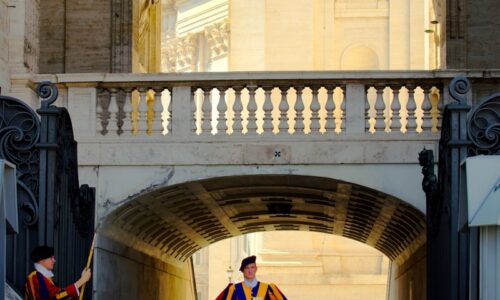 man in red and black suit standing on gray concrete floor