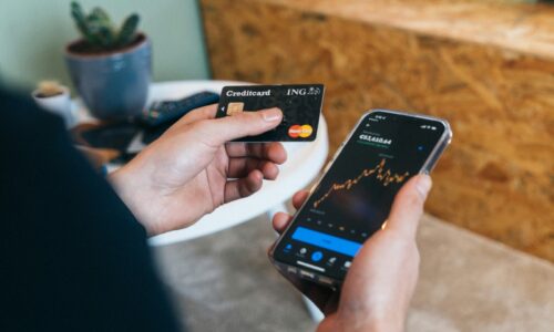 a person holding a smart phone and a credit card