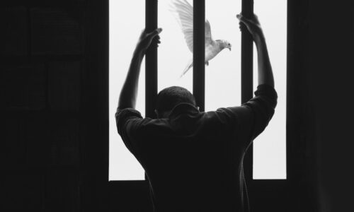 man in black long sleeve shirt raising his right hand
