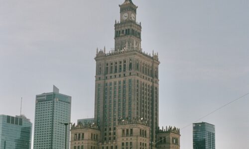 a large building with a clock tower in the middle of a city