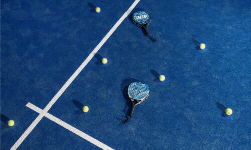 two tennis rackets and balls on a blue tennis court