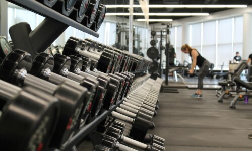 woman standing surrounded by exercise equipment