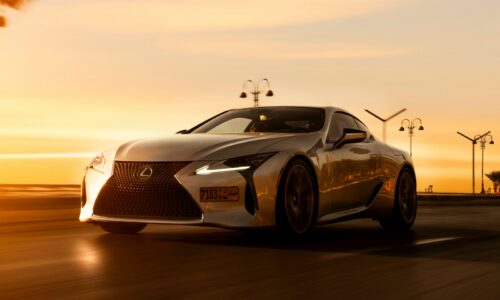 a silver sports car driving down a road