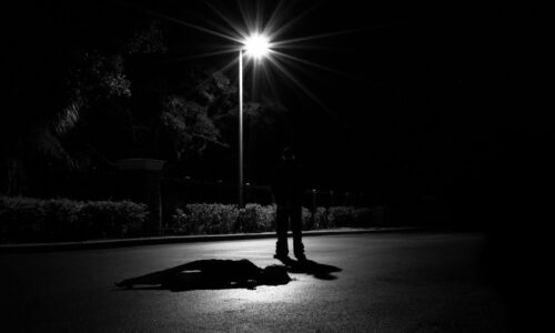 a person laying on the ground under a street light