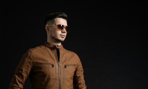 man in brown leather zip up jacket wearing black sunglasses
