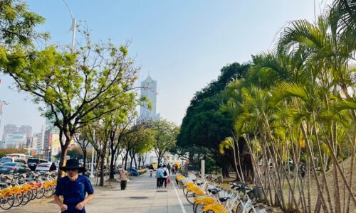 A man running down a street next to a row of parked bikes