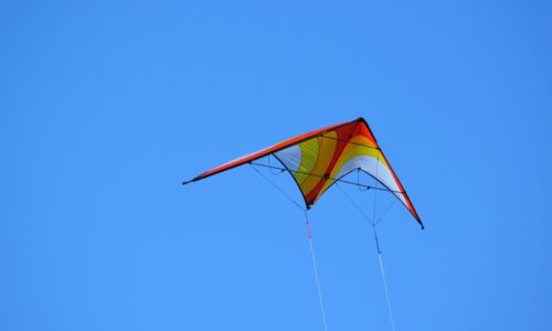 A kite flying high in the blue sky
