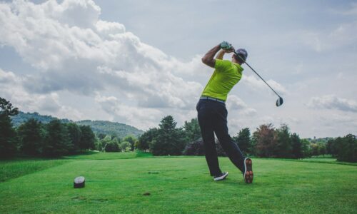 photo of man swinging golf driver