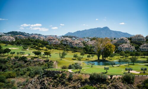 A scenic view of a golf course and mountains