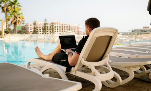man on sun lounger using laptop
