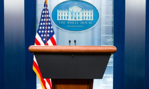 a podium with an american flag and the white house