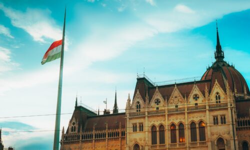 Hungarian flag flying at half-mast over parliament building.