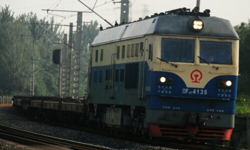 a blue and white train traveling down train tracks